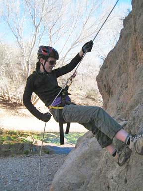 Student rappelling down cliff face